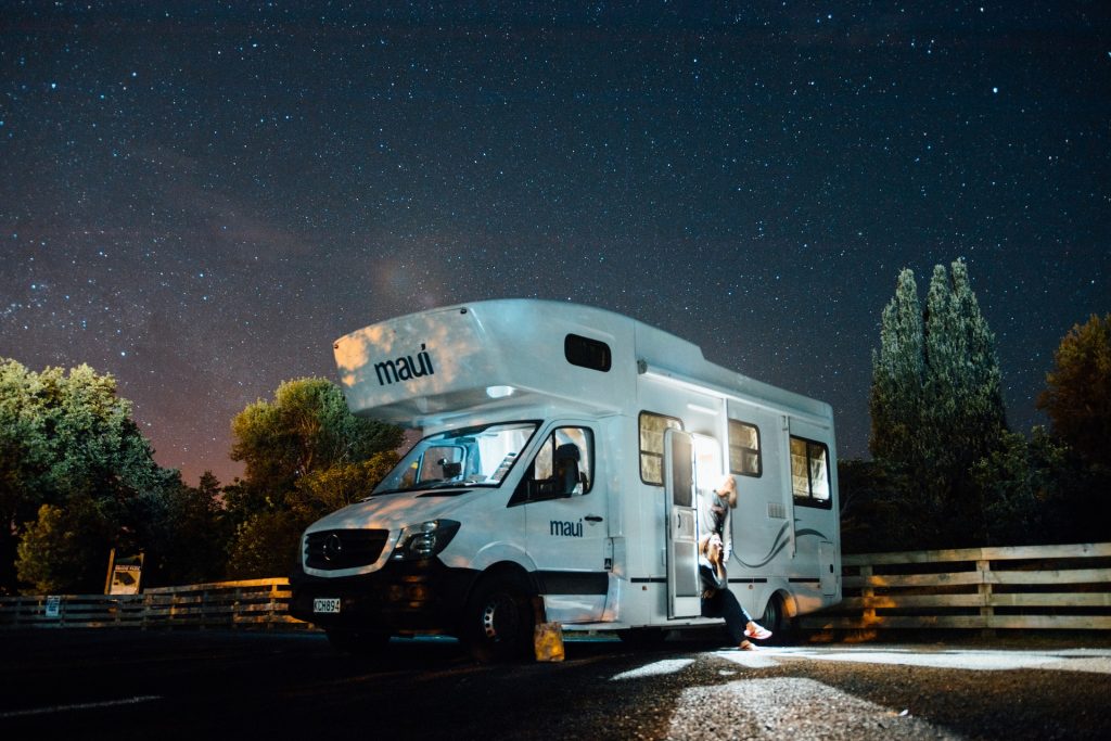 RV parked at night with lights on.